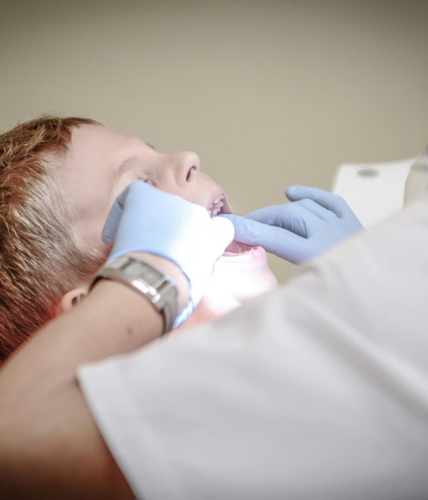Dentist Woman Wearing White Gloves and White Scrubsuit Checking Boy's Teeth